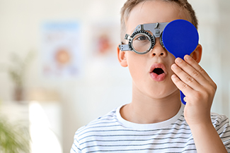 pediatric eye exam patient covering eye doing eye test.jpg